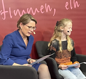 Auf dem Foto ist Bildungsministerin Hubig mit der diesjährigen Landessiegerin des Vorlesewettbewerbs Rheinland-Pfalz, Mia-Luisa Küstner zu sehen