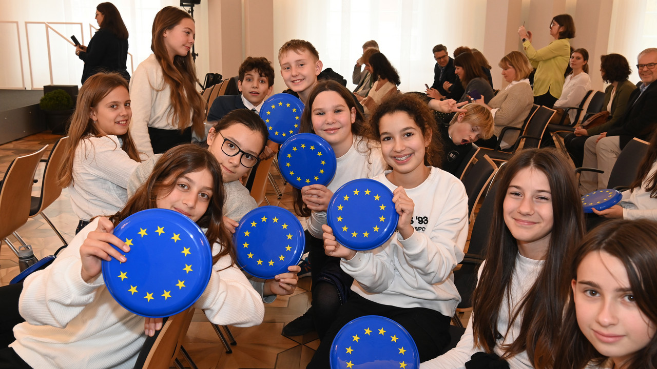 Schülerinnen und Schüler halten Frisbees mit der europäischen Fahne in die Kamera. 