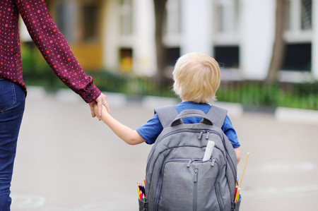 Kleiner Schüler mit seiner Mutter. Erster Tag in der Grundschule.