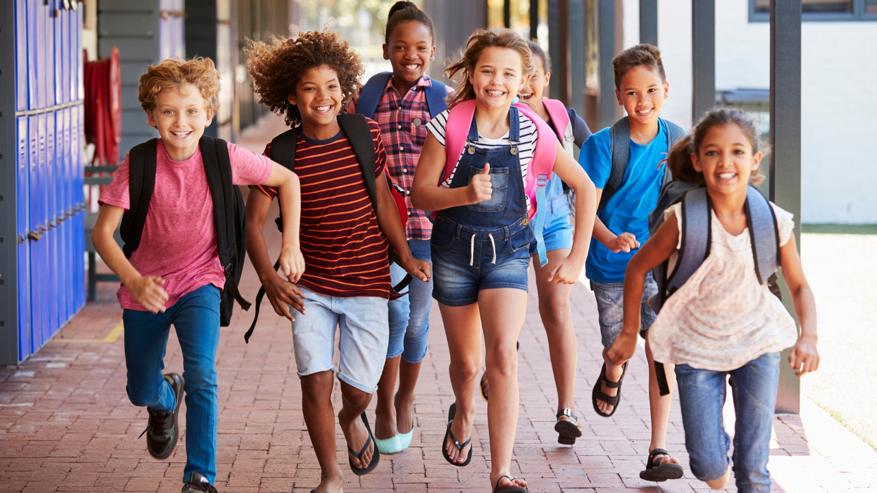 Kinder laufen auf dem Gang im Schulgebäude.