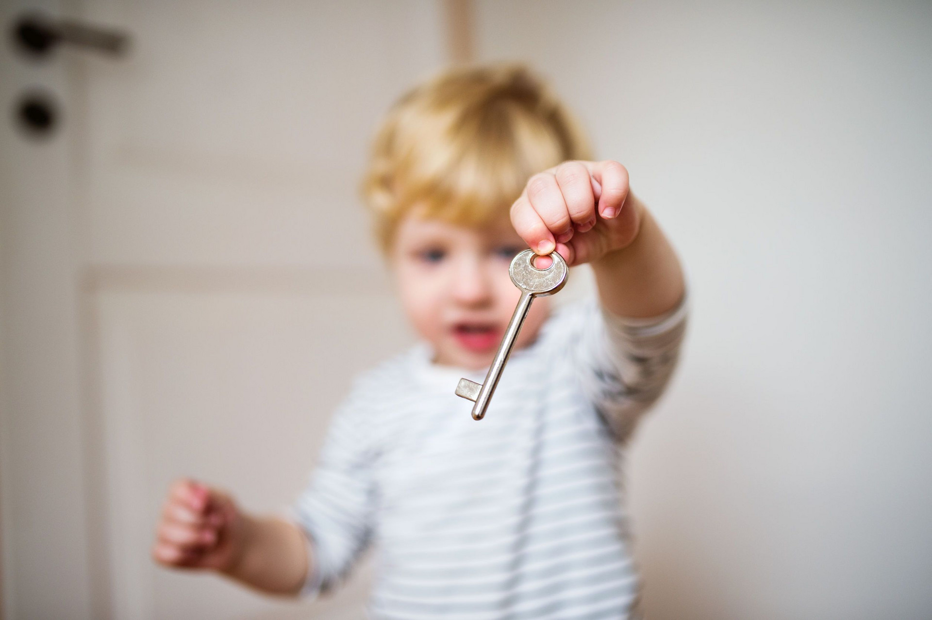 Kind hält einen Schlüssel in der Hand.