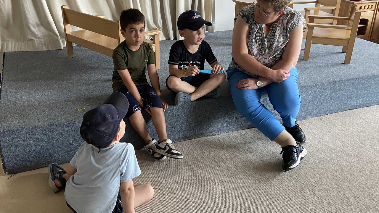 Staatssekretärin Brück im Gespräch mit drei Kindergartenkindern. 